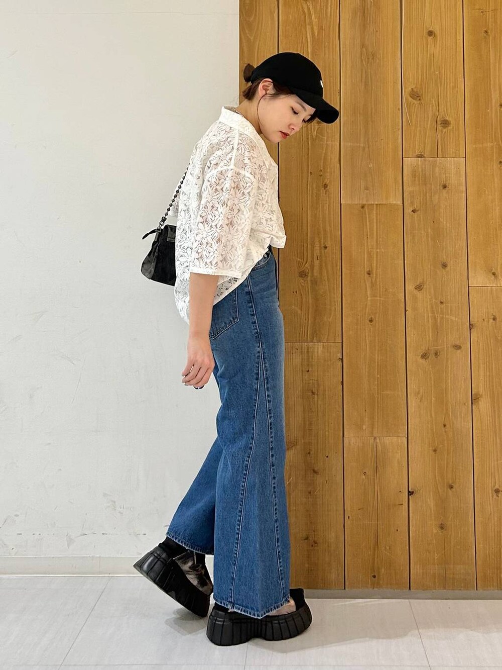 ブラック系のスニーカー、ブルー系のデニムパンツ、ホワイト系のシャツ/ブラウスを着用したレディースの春コーディネートの3枚目の写真