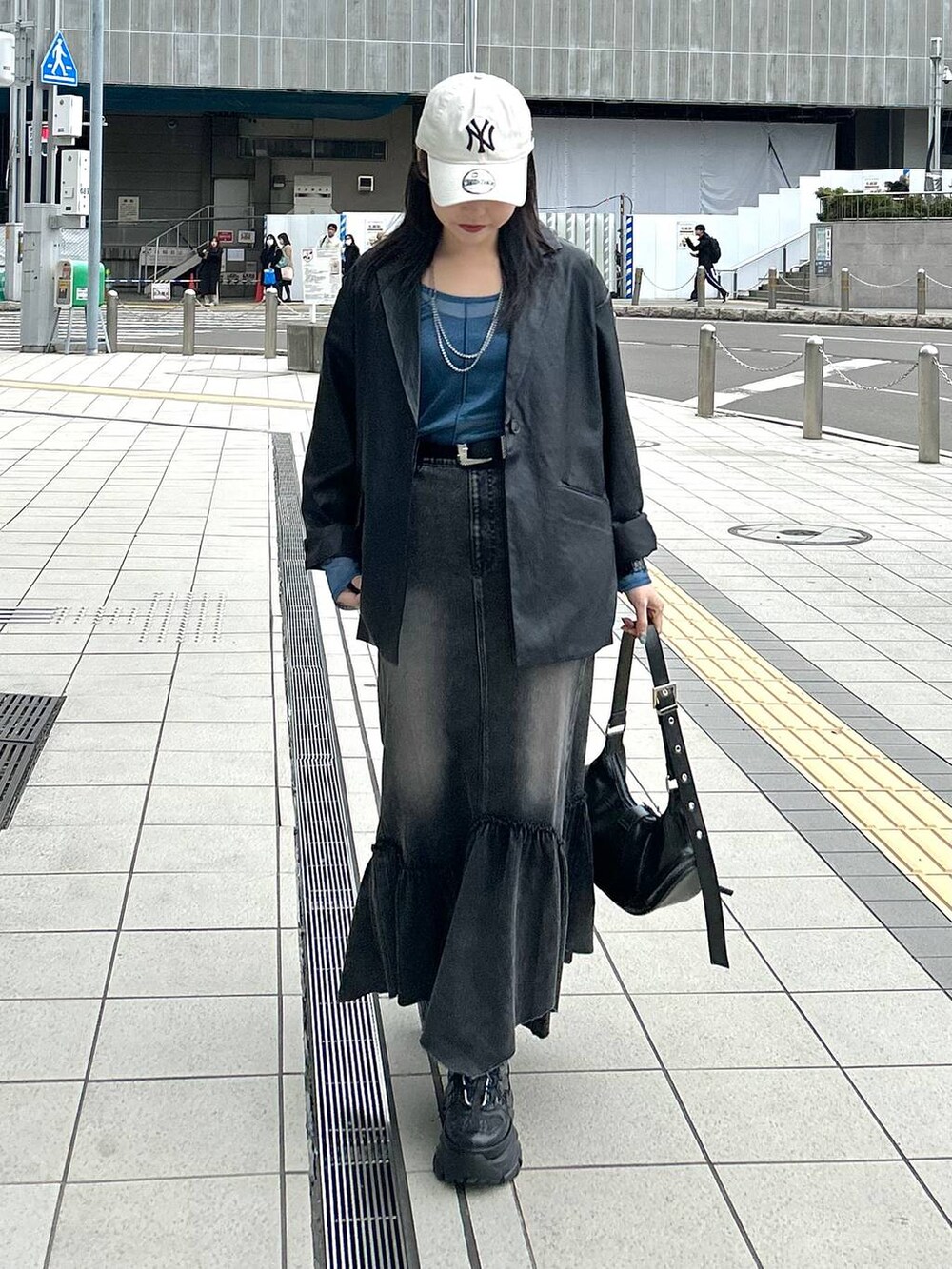 ブラック系のスニーカー、ブラック系のテーラードジャケット、ブラック系のショルダーバッグを着用したレディースの春コーディネートの2枚目の写真