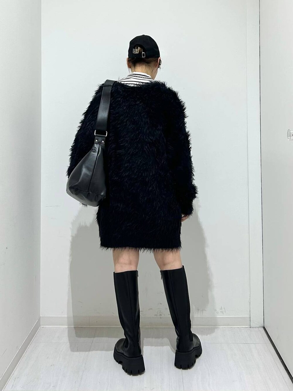 ブラック系のカーディガン/ボレロ、ブラック系のブーツ、ブラック系のショルダーバッグを着用したレディースの秋コーディネートの6枚目の写真