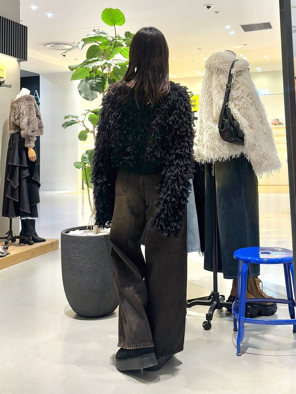 ブラック系のカーディガン/ボレロ、ブラック系のデニムパンツ、ブラック系のベルトを着用したレディースの冬コーディネートの5枚目の写真