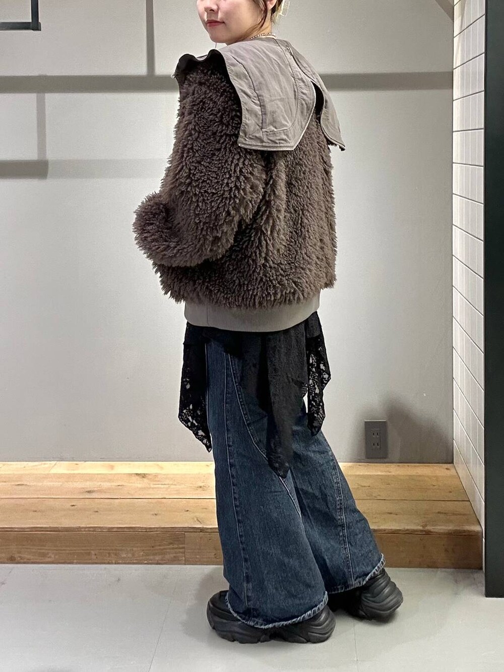 ブラック系のスニーカー、ブルー系のデニムパンツ、ブラック系のブルゾンを着用したレディースの秋コーディネートの6枚目の写真