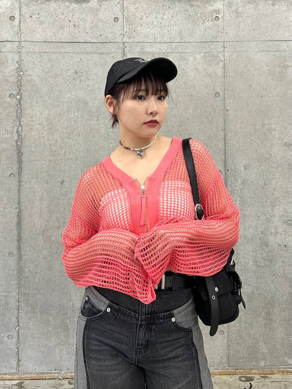 ピンク系のカーディガン/ボレロ、ブラック系のデニムパンツ、ベージュ系のキーホルダーを着用したレディースの冬コーディネートの3枚目の写真