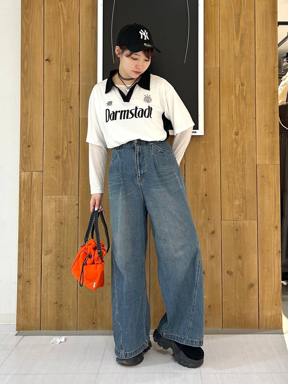 ホワイト系のTシャツ/カットソー、ブルー系のデニムパンツ、オレンジ系のショルダーバッグを着用したレディースの春コーディネートの3枚目の写真