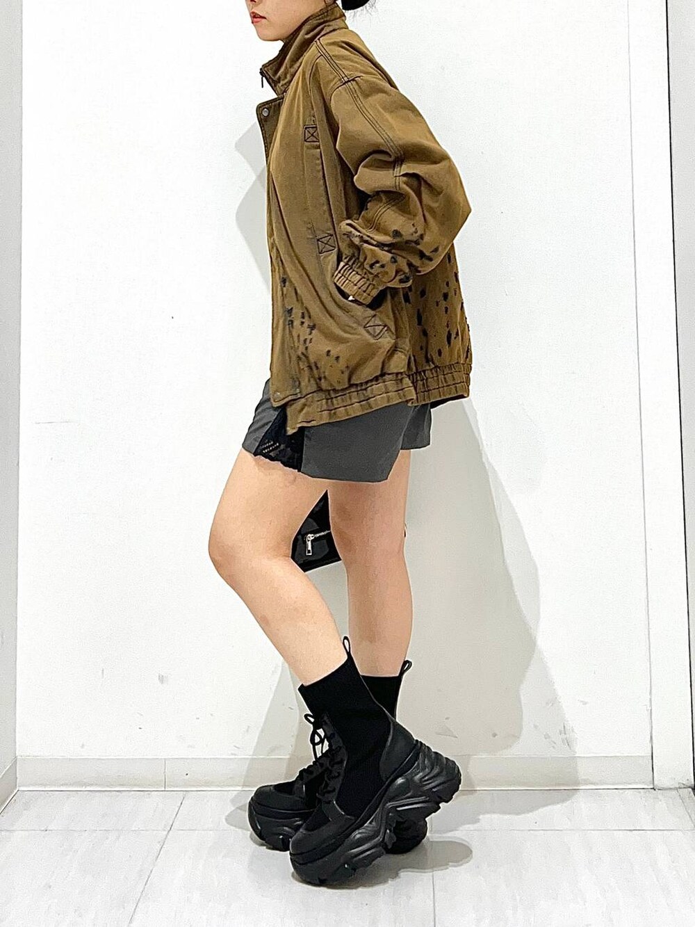 ブラック系のショルダーバッグ、ブラウン系のデニムジャケット、ブラック系のブーツを着用したレディースの秋コーディネートの4枚目の写真