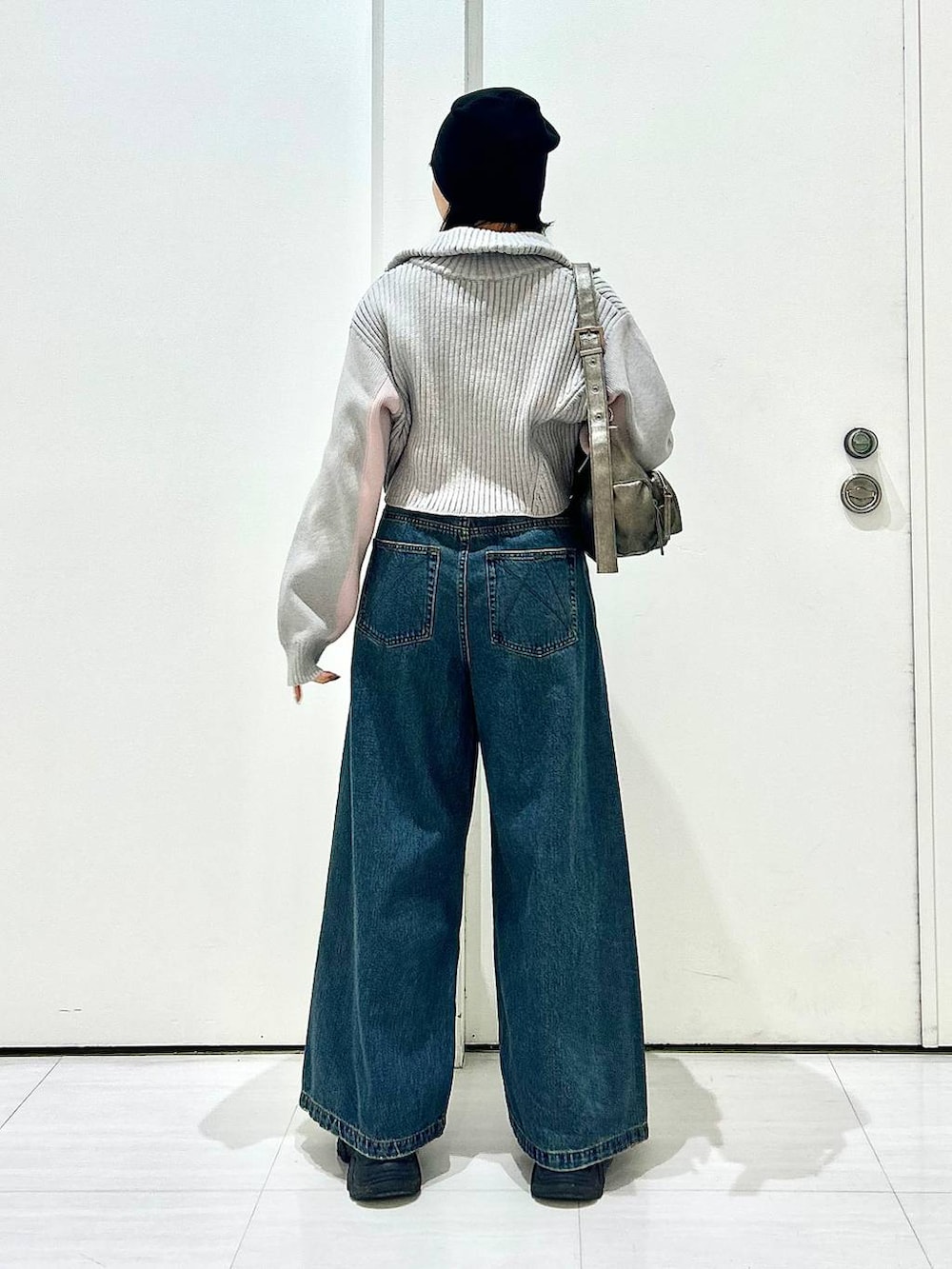 ブルー系のデニムパンツ、グレー系のショルダーバッグ、グレー系のニット/セーターを着用したレディースの秋コーディネートの4枚目の写真