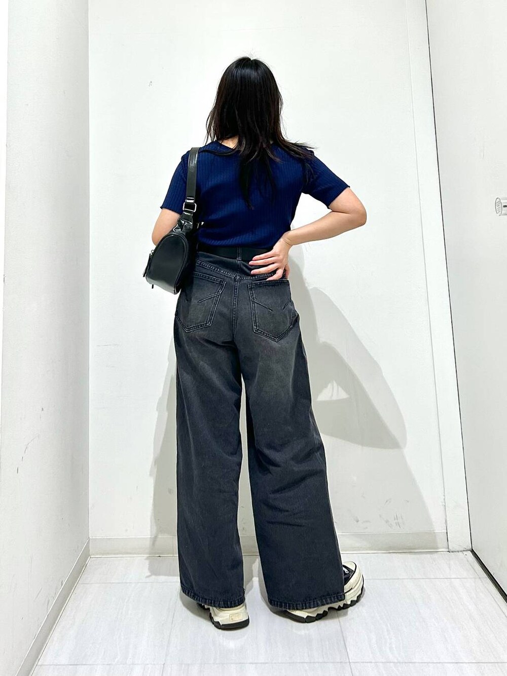 ブラック系のデニムパンツ、ブルー系のニット/セーター、ブラック系のベルトを着用したレディースの春コーディネートの7枚目の写真