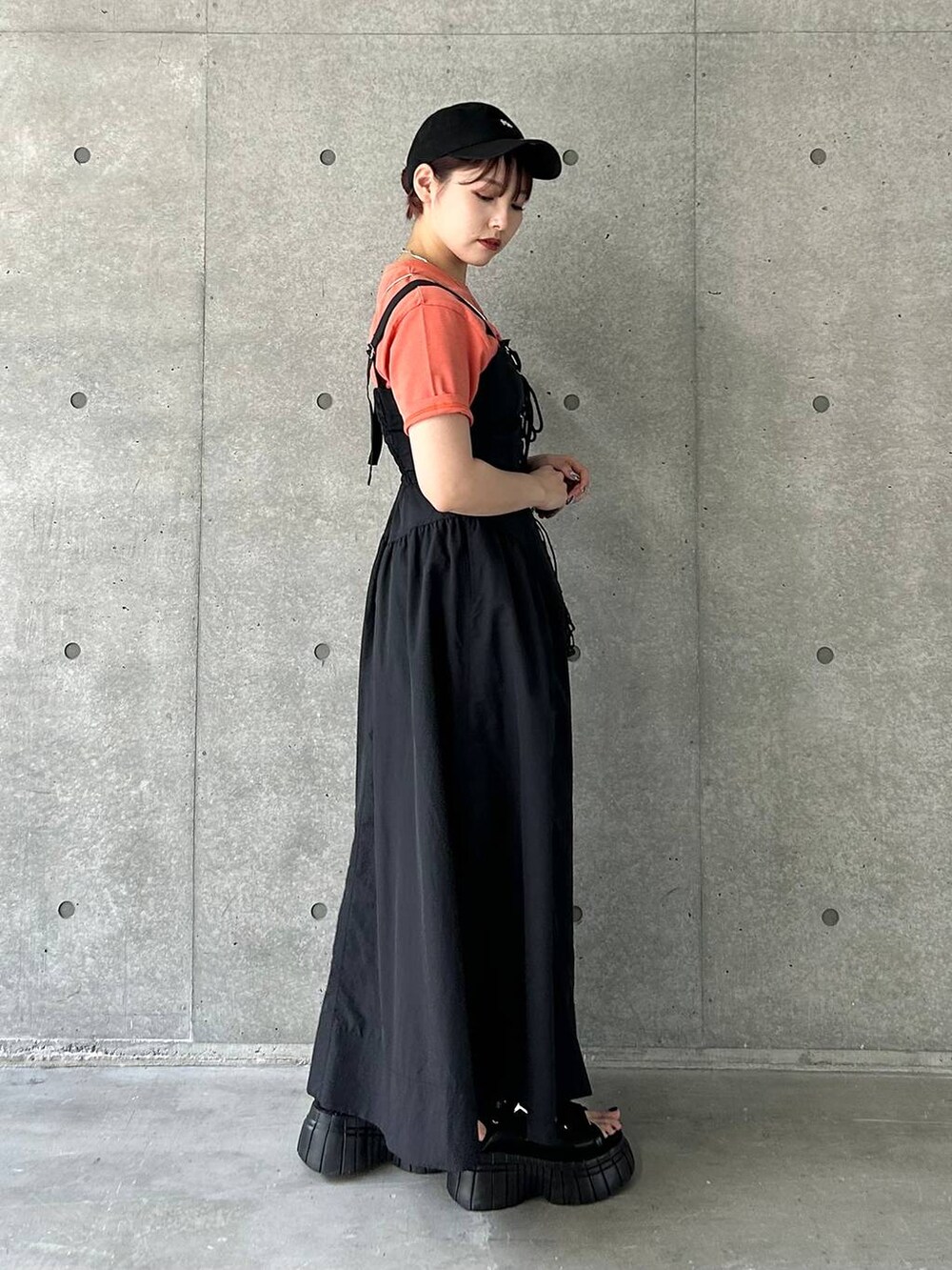 ブラック系のスニーカー、ブラック系のショルダーバッグ、ブラック系のワンピースを着用したレディースの夏コーディネートの4枚目の写真