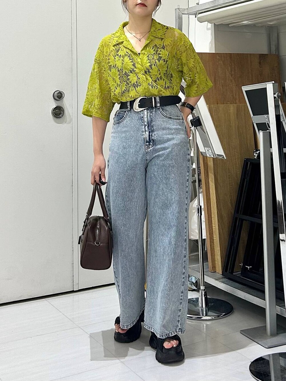 ブラック系のサンダル、ブラック系のキャミソール、ブルー系のデニムパンツを着用したレディースの夏コーディネートの2枚目の写真