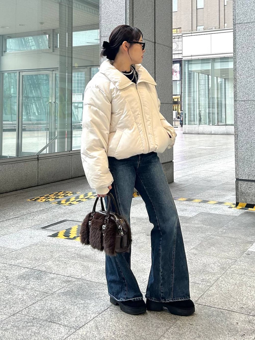 ブルー系のデニムパンツ、ホワイト系のブルゾン、ブラック系のブーツを着用したレディースの冬コーディネートの4枚目の写真