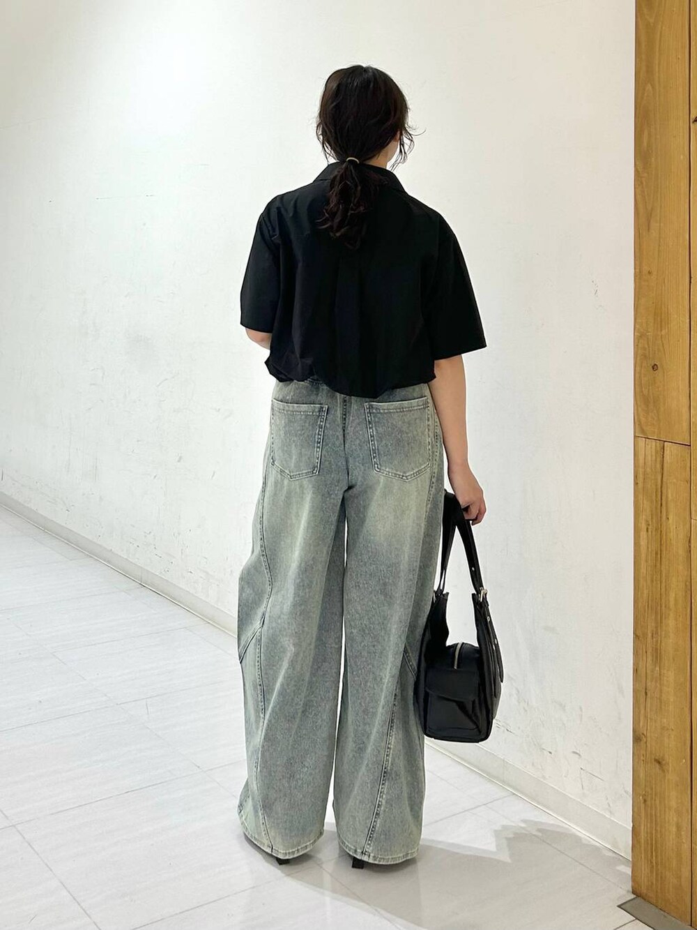 ブルー系のデニムパンツ、ブラック系のサンダル、ブラック系のベルトを着用したレディースの夏コーディネートの8枚目の写真