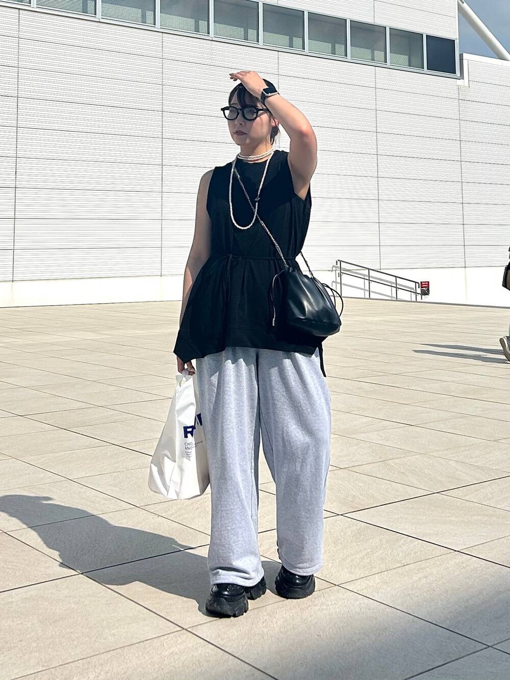 ブラック系のスニーカー、グレー系のスウェットパンツ、ブラック系のTシャツ/カットソーを着用したレディースの夏コーディネートの4枚目の写真