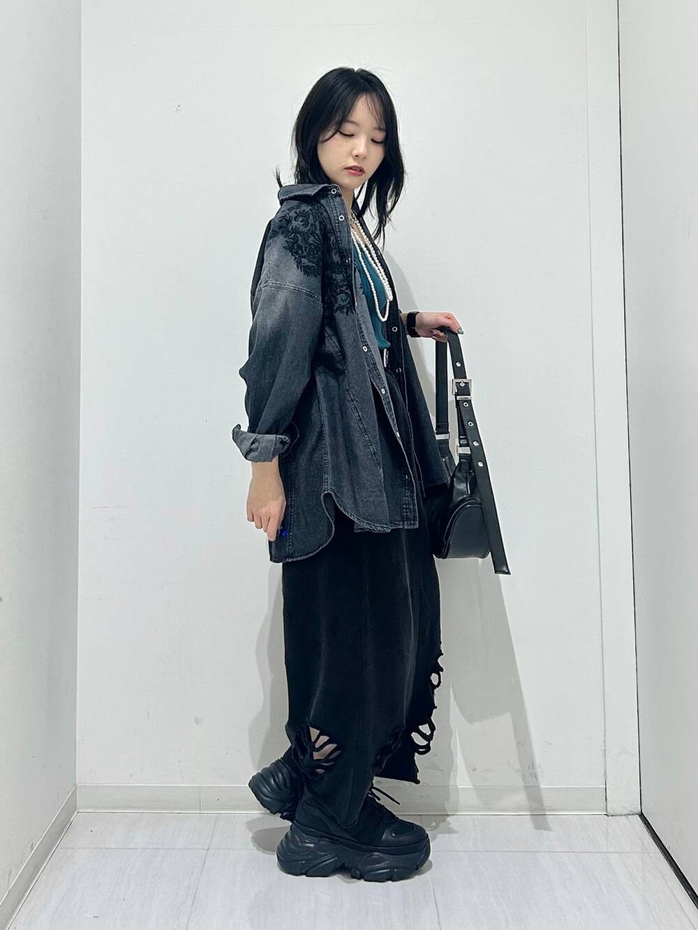 ブラック系のスニーカー、ブラック系のショルダーバッグ、ブラック系のシャツ/ブラウスを着用したレディースの春コーディネートの6枚目の写真