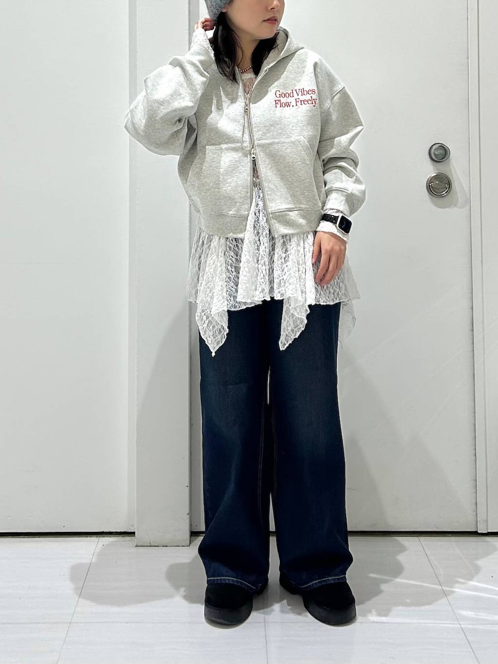 ブルー系のスラックス、グレー系のパーカー、ホワイト系のチュニックを着用したレディースの冬コーディネートの2枚目の写真