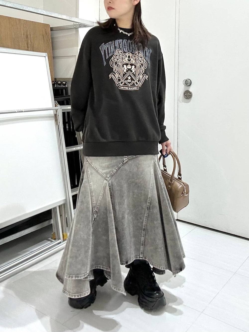 ブラック系のブーツ、グレー系のスウェット、ブラウン系のボストンバッグを着用したレディースの冬コーディネートの6枚目の写真