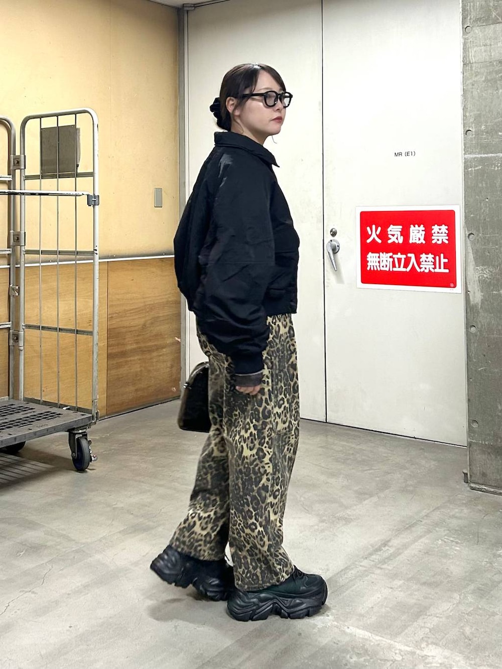 ブラック系のスニーカー、ブラック系のブルゾン、ブラック系のニット/セーターを着用したレディースの冬コーディネートの4枚目の写真