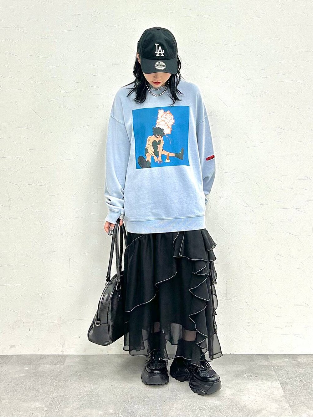 ブラック系のスニーカー、ブラック系のスカート、ブルー系のスウェットを着用したレディースの冬コーディネートの2枚目の写真