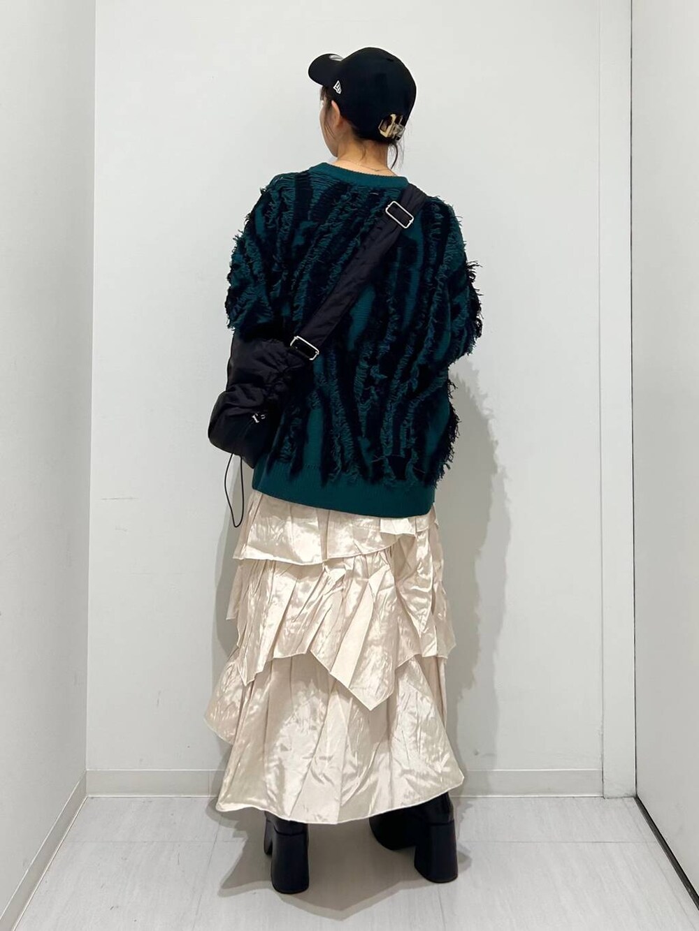 ベージュ系のスカート、ブラック系のブーツ、ブラック系のショルダーバッグを着用したレディースの秋コーディネートの5枚目の写真