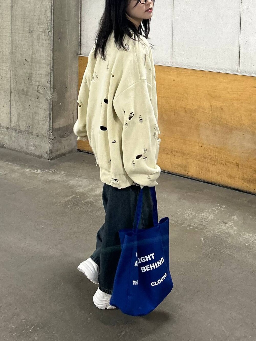 ホワイト系のスニーカー、ブルー系のデニムパンツ、ブルー系のトートバッグを着用したレディースの春コーディネートの5枚目の写真