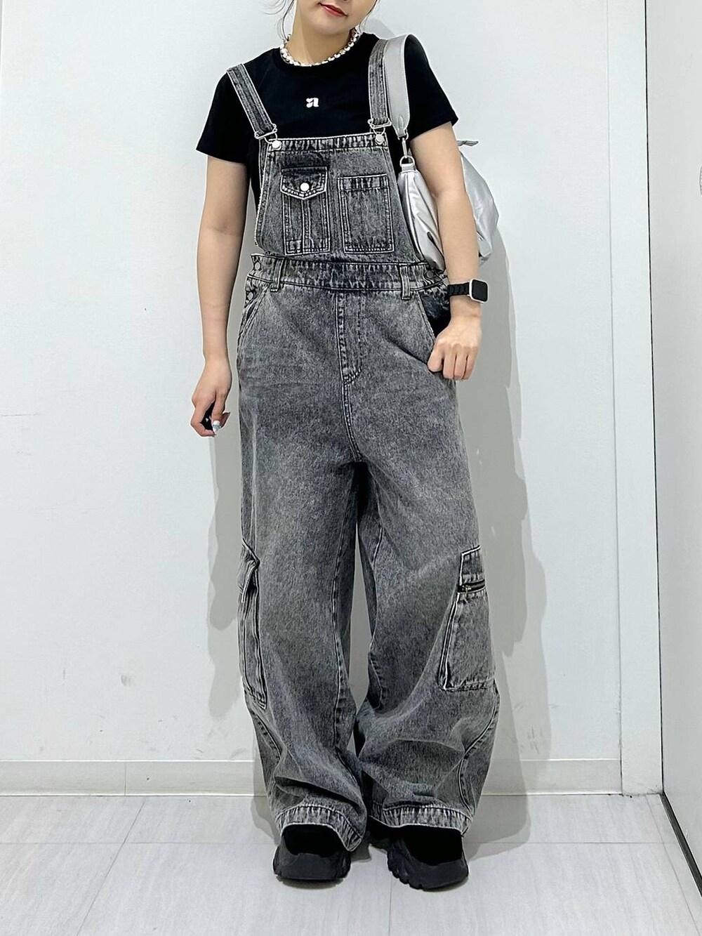 ブラック系のサロペット/オーバーオール、シルバー系のショルダーバッグ、ブラック系のTシャツ/カットソーを着用したレディースの夏コーディネートの2枚目の写真
