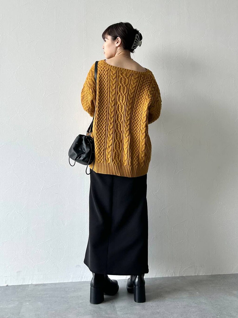 ブラック系のスカート、ブラック系のキャミソール、イエロー系のニット/セーターを着用したレディースの秋コーディネートの6枚目の写真