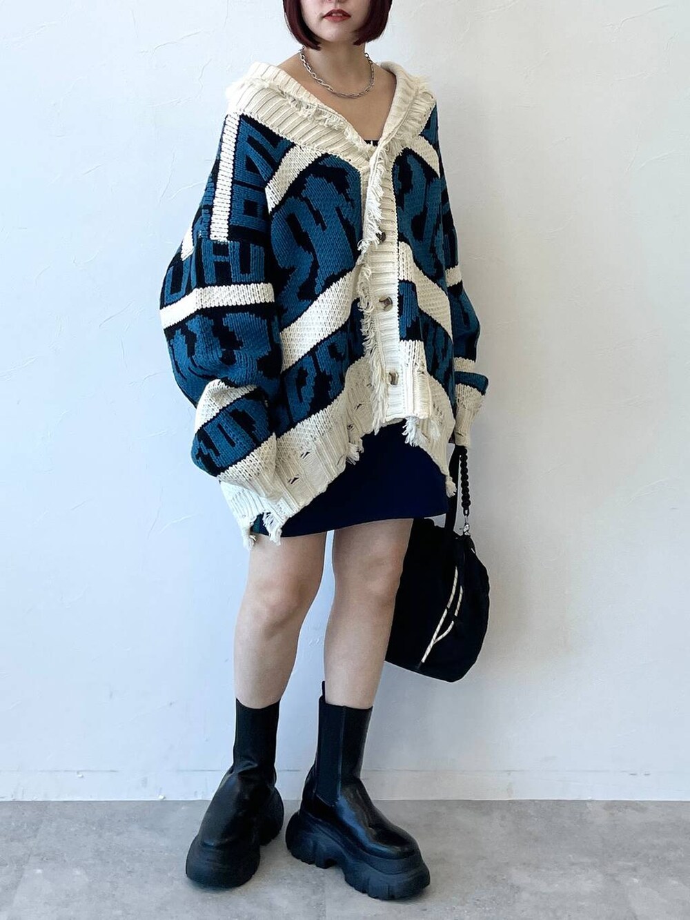 ブラック系のキャミソール、ブラック系のブーツ、ブルー系のスカートを着用したレディースの秋コーディネートの3枚目の写真