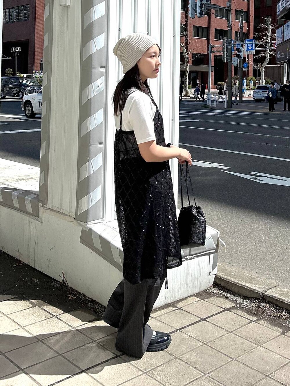 ブラック系のスニーカー、グレー系のカーゴパンツ、ブラック系のワンピースを着用したレディースの春コーディネートの6枚目の写真