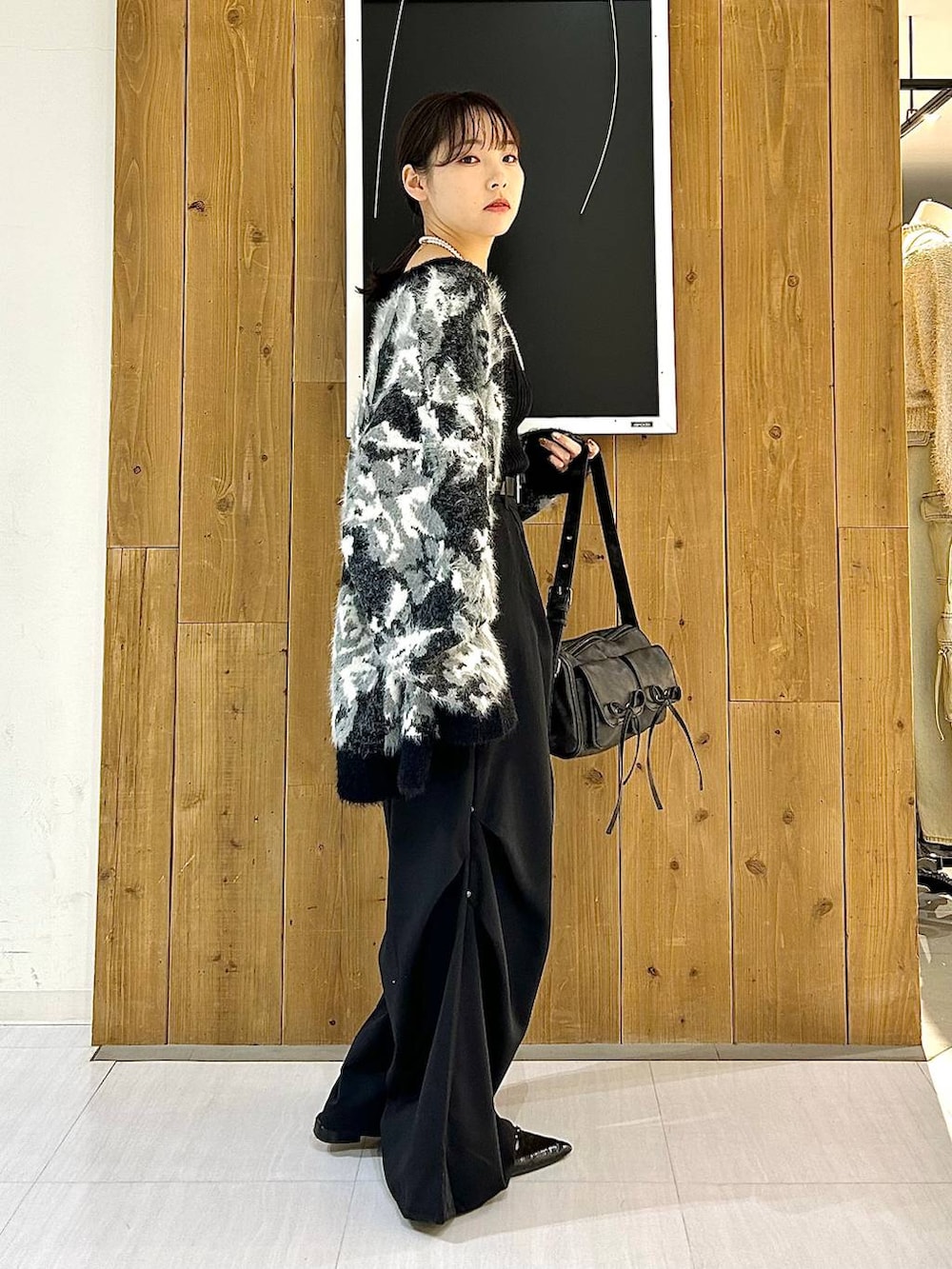 ブラック系のタンクトップ、ブラック系のパンプス、ブラック系のショルダーバッグを着用したレディースの秋コーディネートの7枚目の写真