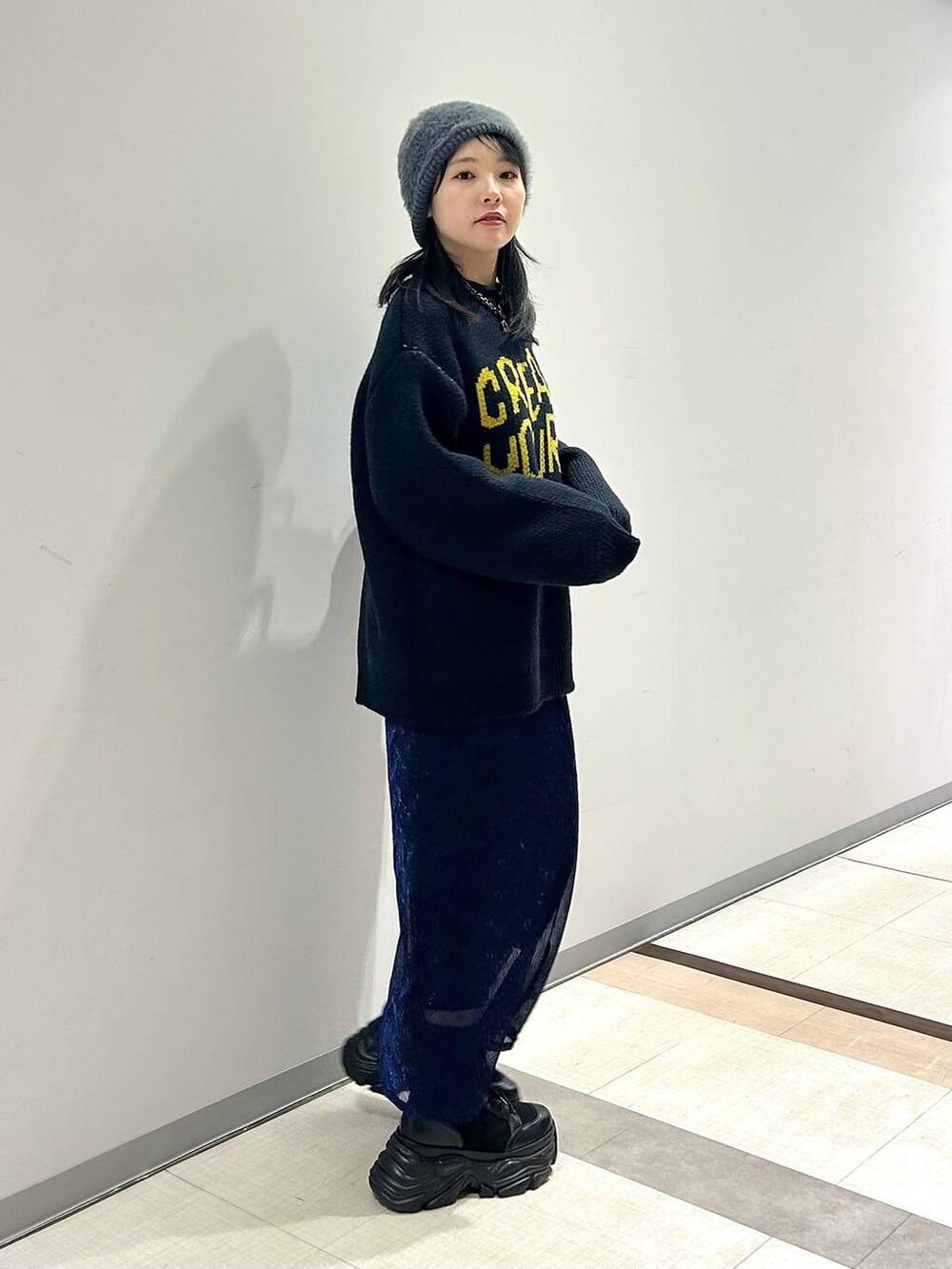 ブラック系のブーツ、その他のショルダーバッグ、ブルー系のニット/セーターを着用したレディースの秋コーディネートの6枚目の写真