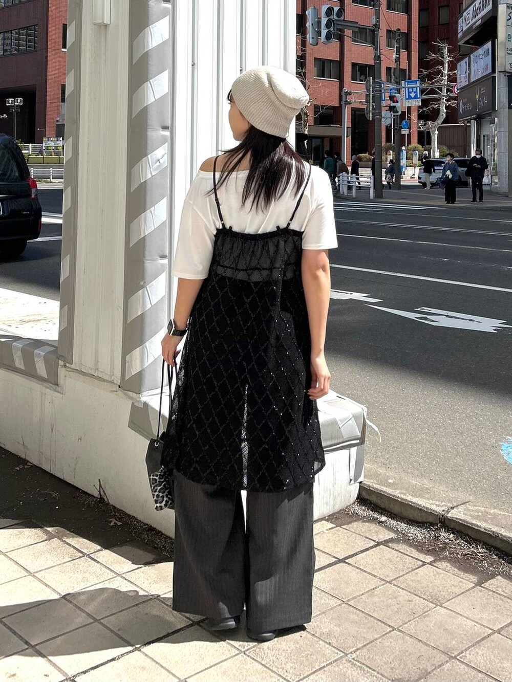 ブラック系のワンピース、ホワイト系のTシャツ/カットソー、ベージュ系のニットキャップ/ビーニーを着用したレディースの春コーディネートの7枚目の写真