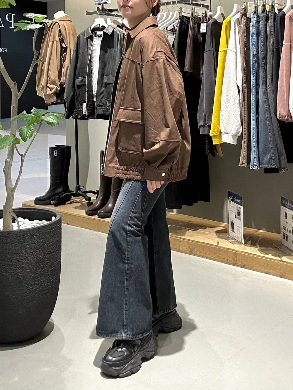 ブラック系のスニーカー、ブルー系のデニムパンツ、ブラック系のTシャツ/カットソーを着用したレディースの秋コーディネートの6枚目の写真