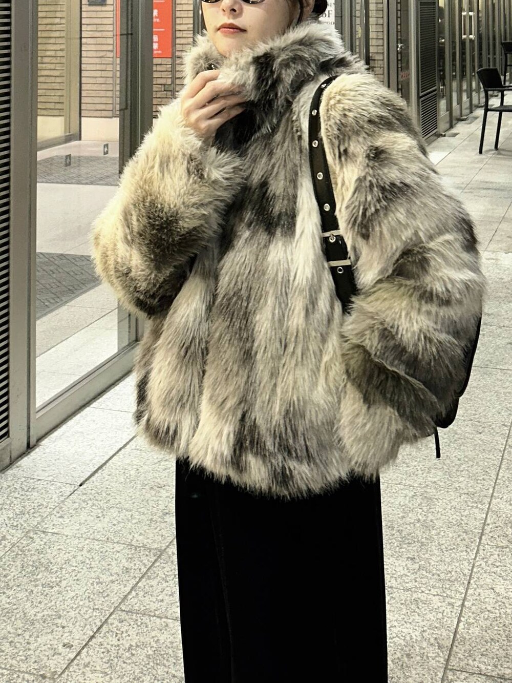 グレー系のブルゾン、ブラック系のショルダーバッグ、ブラック系のその他パンツを着用したレディースの秋コーディネートの2枚目の写真