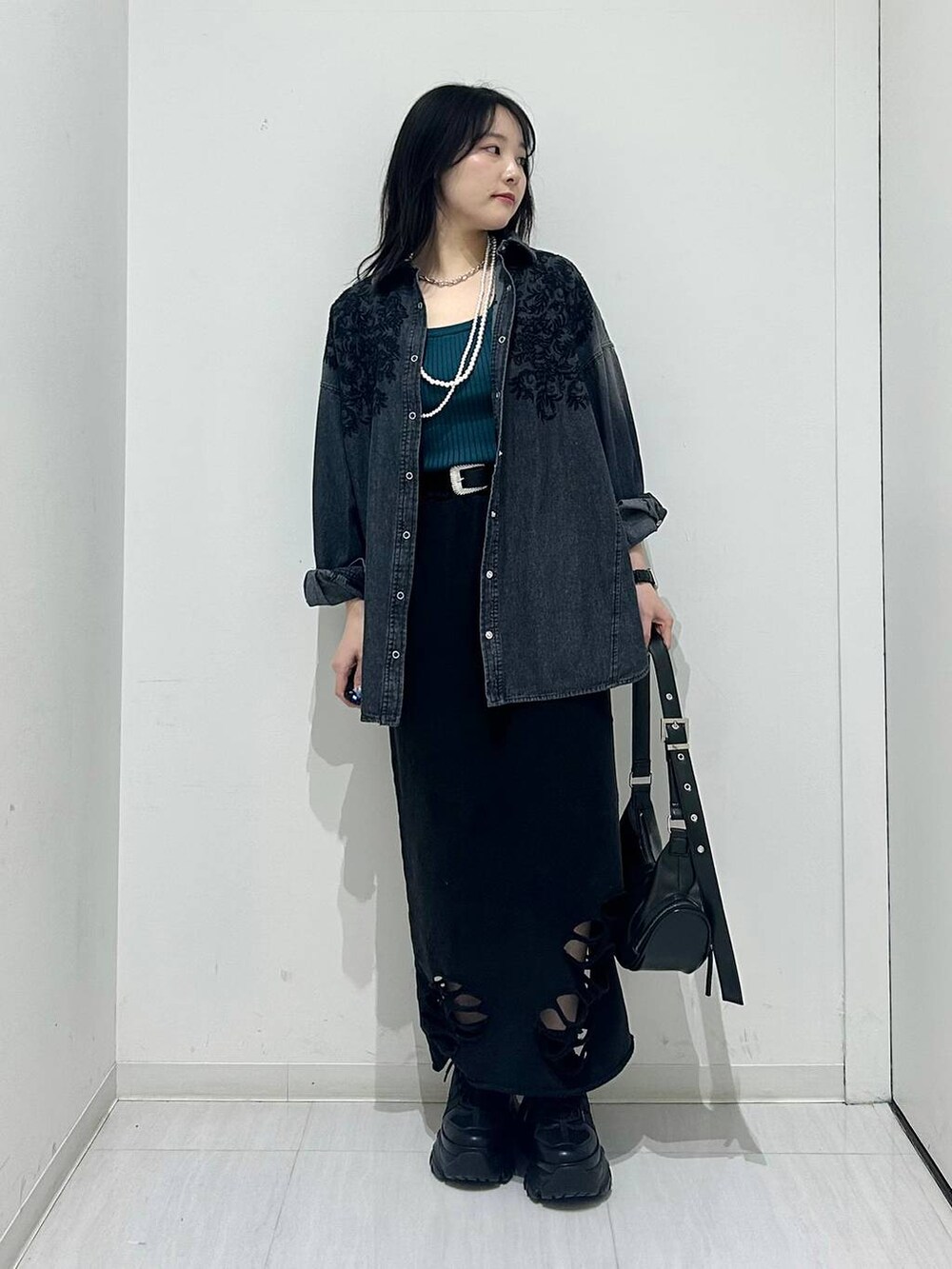 ブラック系のスニーカー、ブラック系のショルダーバッグ、ブラック系のシャツ/ブラウスを着用したレディースの春コーディネートの3枚目の写真