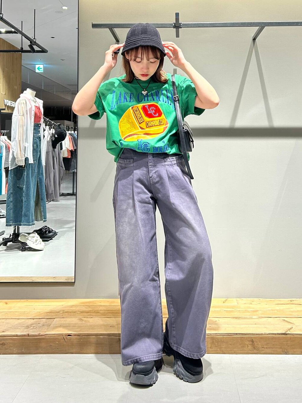ブラック系のハンドバッグ、グリーン系のTシャツ/カットソー、ブラック系のデニムパンツを着用したレディースの春コーディネートの3枚目の写真