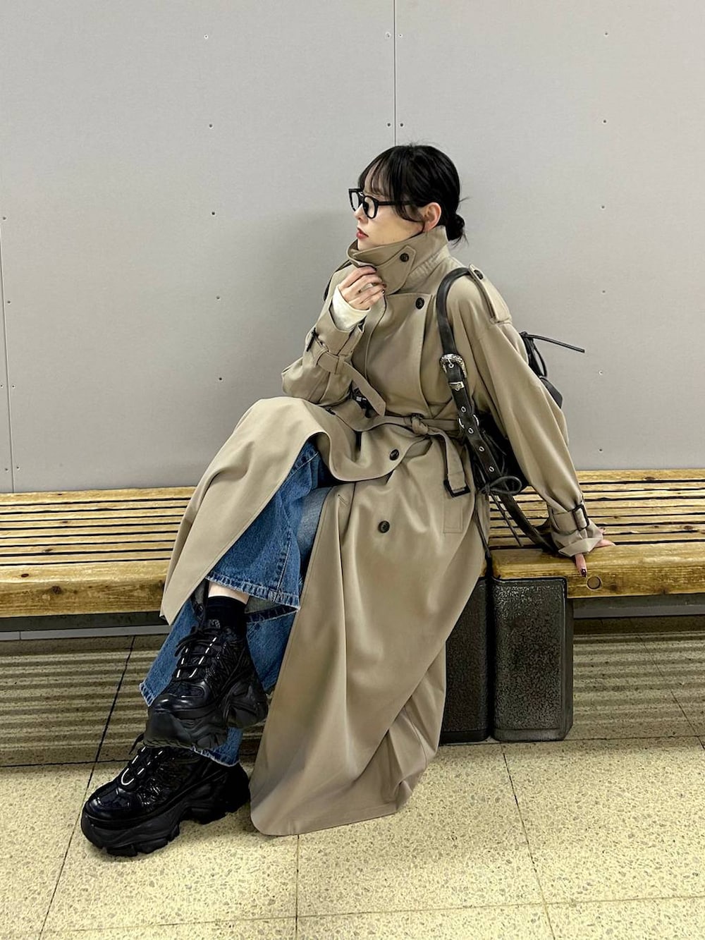 ブラック系のスニーカー、ブルー系のデニムパンツ、ブラック系のショルダーバッグを着用したレディースの春コーディネートの4枚目の写真