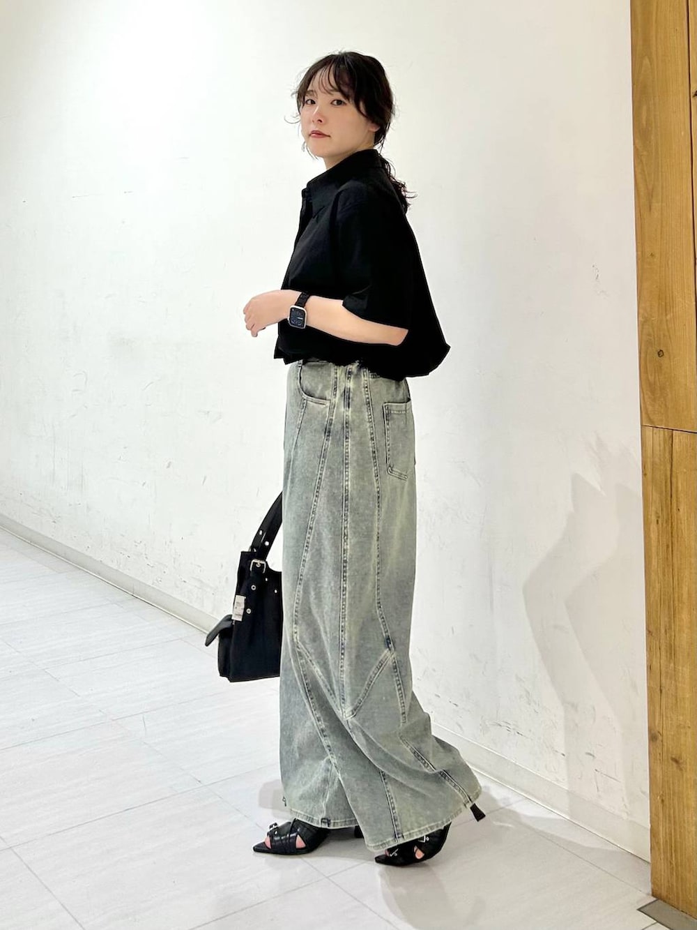 ブルー系のデニムパンツ、ブラック系のサンダル、ブラック系のベルトを着用したレディースの夏コーディネートの4枚目の写真