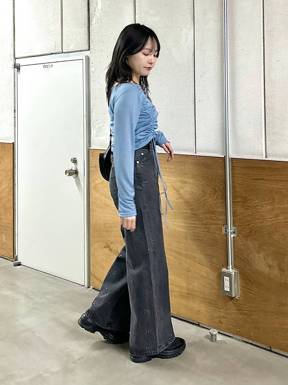 ブラック系のデニムパンツ、ブラック系のスニーカー、ブラック系のショルダーバッグを着用したレディースの春コーディネートの9枚目の写真