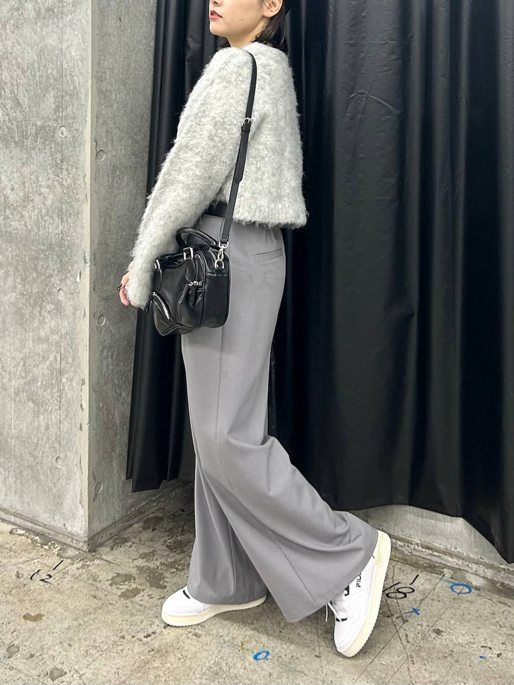 ホワイト系のスニーカー、グレー系のニット/セーター、ブラック系のベルトを着用したレディースの秋コーディネートの4枚目の写真
