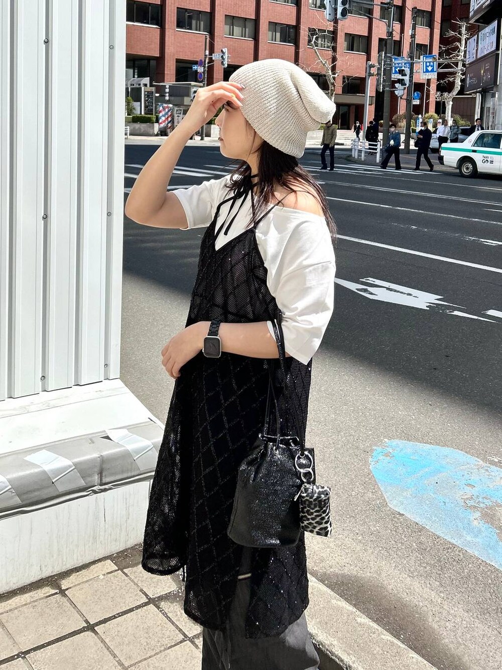 ブラック系のワンピース、ホワイト系のTシャツ/カットソー、ベージュ系のニットキャップ/ビーニーを着用したレディースの春コーディネートの2枚目の写真