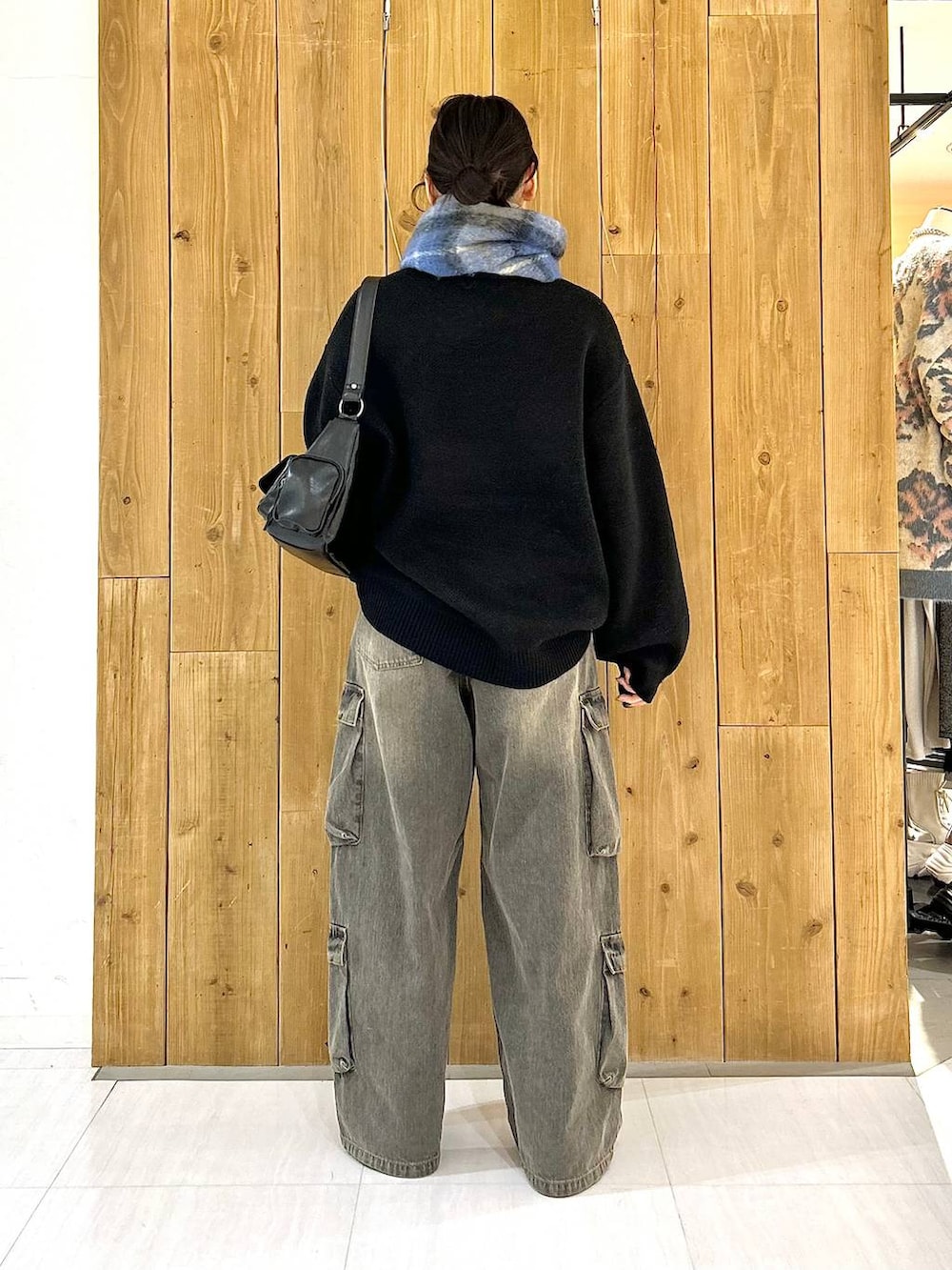 ブラック系のショルダーバッグ、ブラック系のニット/セーター、ブラック系のデニムパンツを着用したレディースの冬コーディネートの4枚目の写真