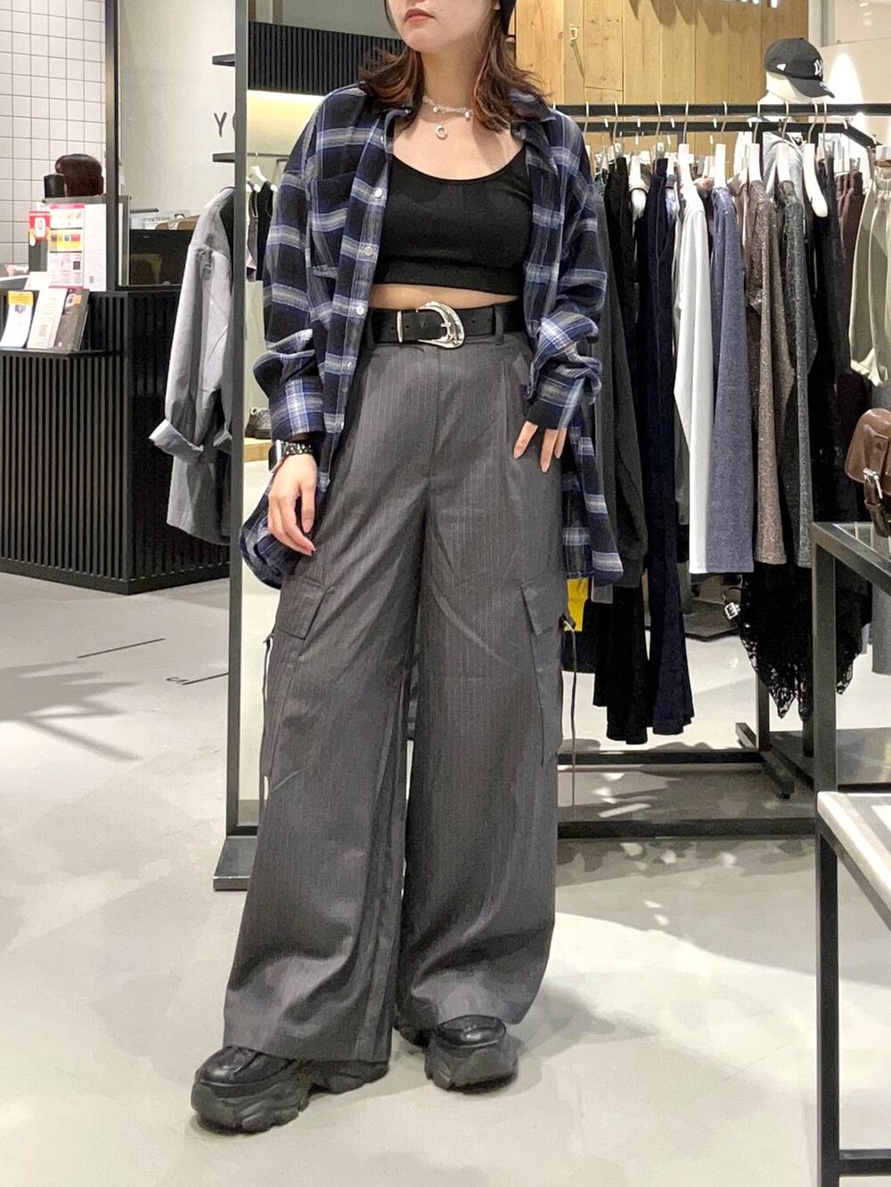 ブラック系のスニーカー、ブルー系のシャツ/ブラウス、グレー系のスラックスを着用したレディースの秋コーディネートの2枚目の写真