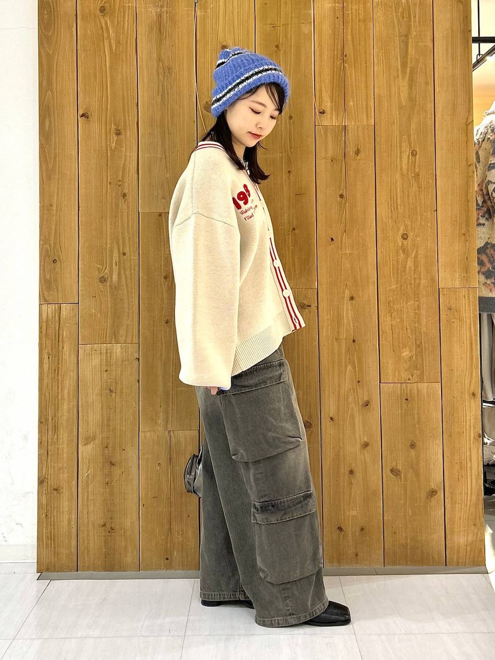 その他のショルダーバッグ、ブラック系のデニムパンツ、ベージュ系のカーディガン/ボレロを着用したレディースの冬コーディネートの4枚目の写真