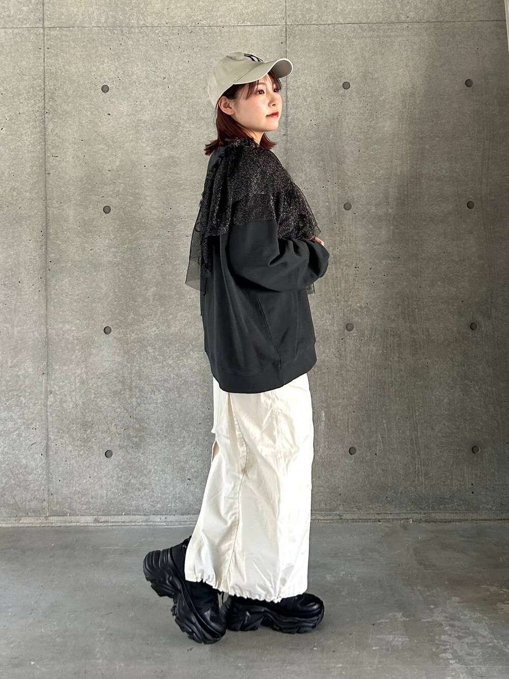 ブラック系のスニーカー、ホワイト系のスカート、ブラック系のスウェットを着用したレディースの春コーディネートの8枚目の写真