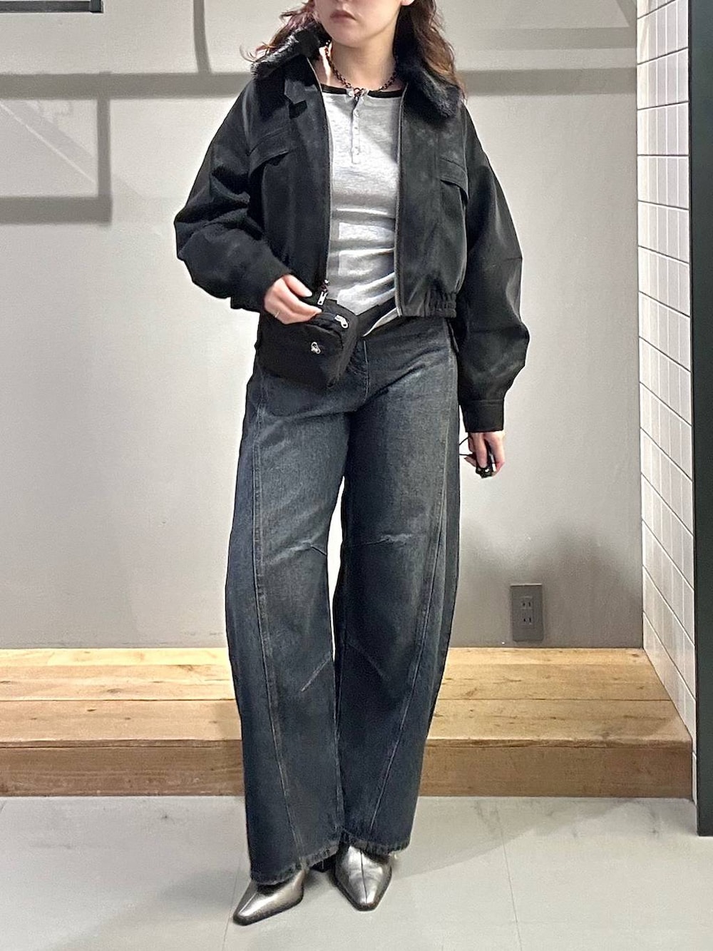 ブルー系のデニムパンツ、グレー系のTシャツ/カットソー、ブラック系のブルゾンを着用したレディースの秋コーディネートの3枚目の写真