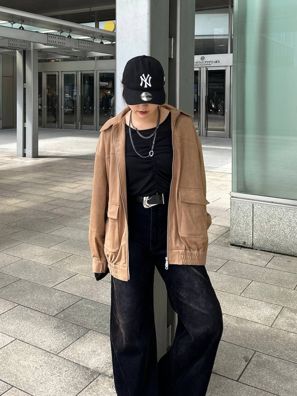 ブラック系のデニムパンツ、イエロー系のブルゾン、ブラック系のTシャツ/カットソーを着用したレディースの秋コーディネートの7枚目の写真