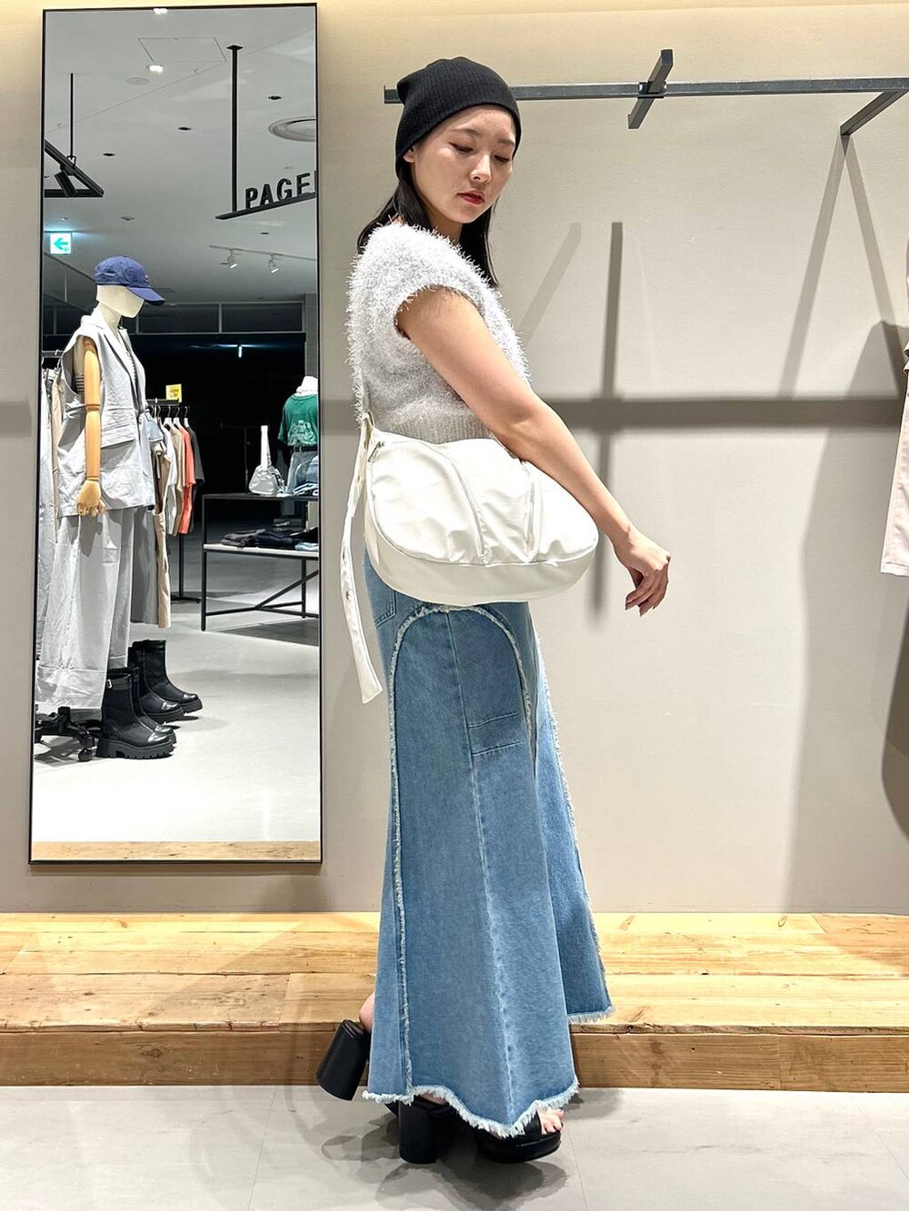 ホワイト系のベスト、ブルー系のデニムスカート、ブラック系のネックレスを着用したレディースの夏コーディネートの5枚目の写真