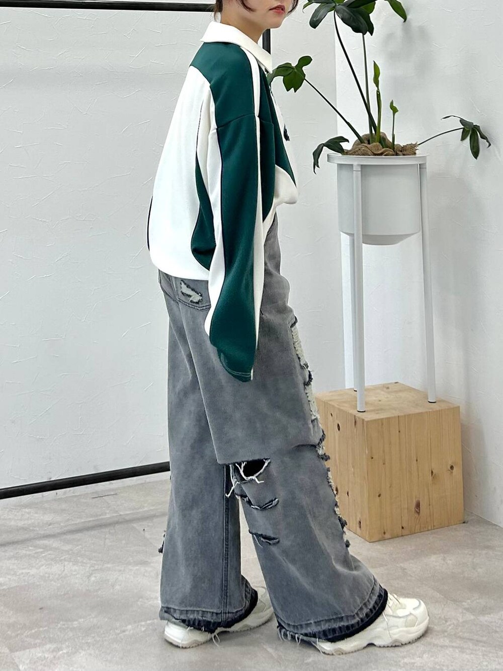 ホワイト系のポロシャツ、ブラック系のデニムパンツ、ブルー系のキャップを着用したレディースの冬コーディネートの5枚目の写真