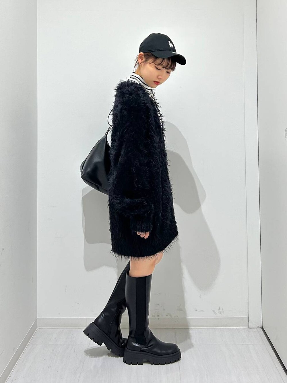 ブラック系のカーディガン/ボレロ、ブラック系のブーツ、ブラック系のショルダーバッグを着用したレディースの秋コーディネートの4枚目の写真