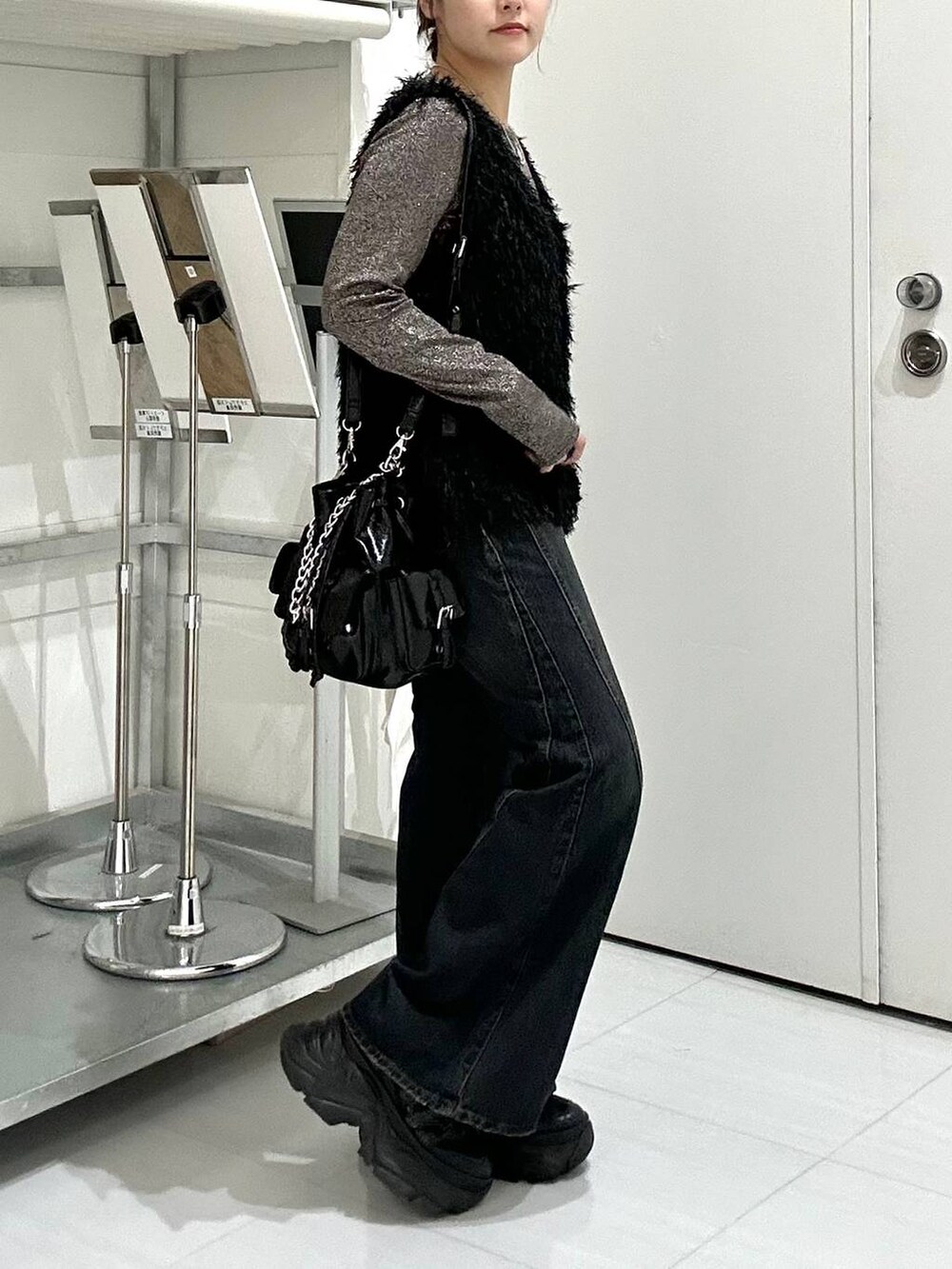 ブラウン系のTシャツ/カットソー、ブルー系のデニムパンツ、ブラック系のベストを着用したレディースの秋コーディネートの4枚目の写真