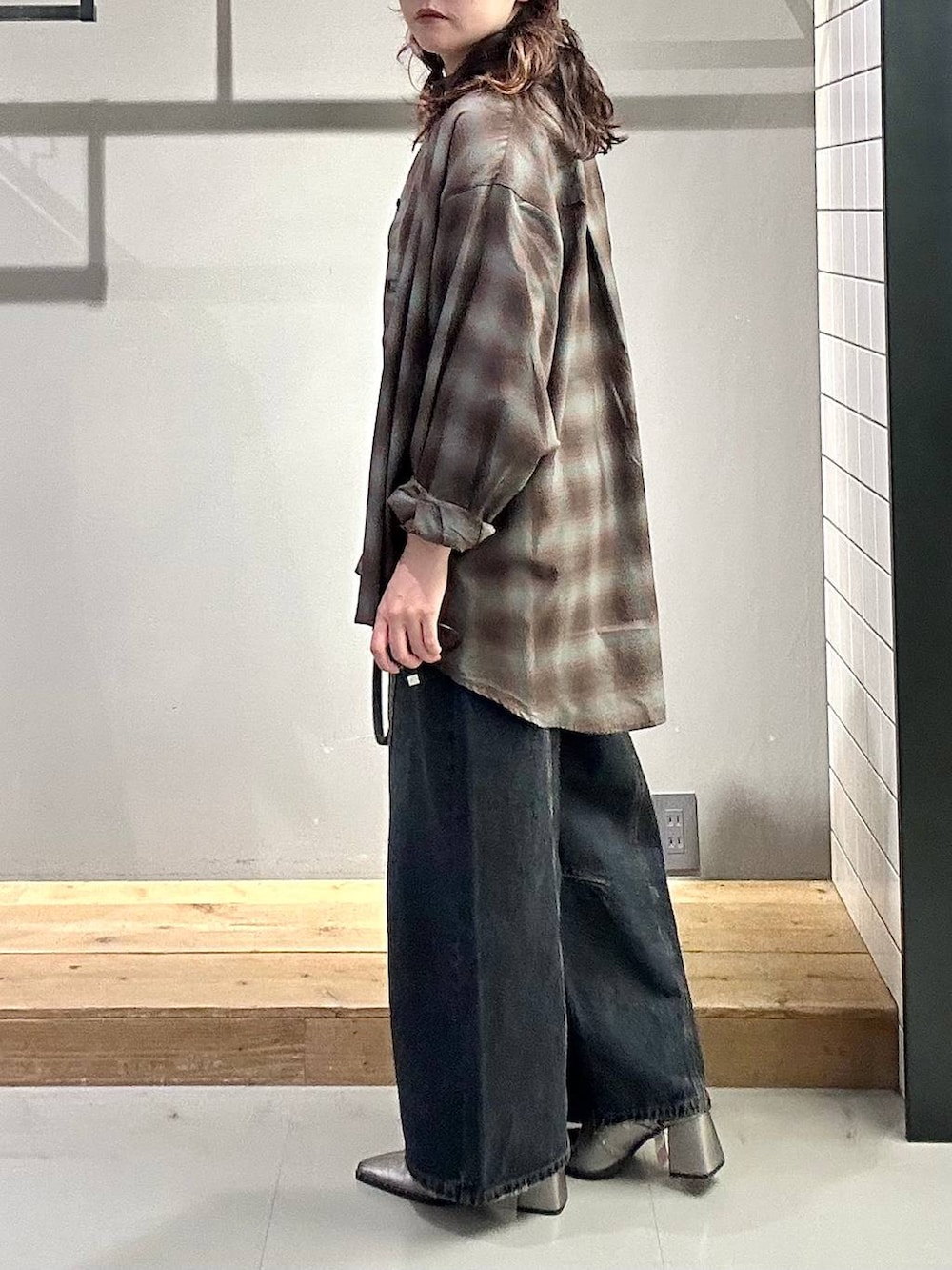 ブラック系のシャツ/ブラウス、ブルー系のデニムパンツ、ブラック系のショルダーバッグを着用したレディースの秋コーディネートの4枚目の写真