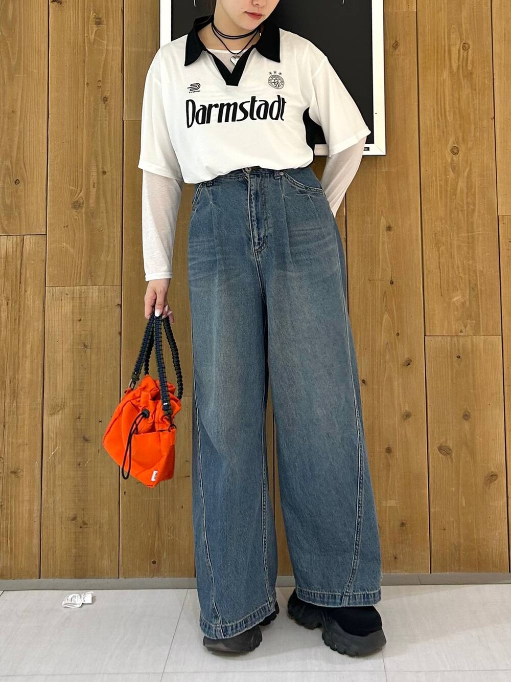 ホワイト系のTシャツ/カットソー、ブルー系のデニムパンツ、オレンジ系のショルダーバッグを着用したレディースの春コーディネートの2枚目の写真